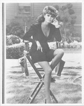 Raquel Welch in short black dress sitting on studio chair between takes 8x10