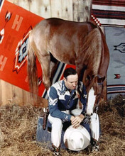 Gene Autry with his horse in stable seated 8x10 inch photo