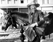 The Shootist 1976 John Wayne holds rifle & pillow by horse 8x10 inch photo
