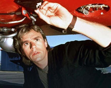 Richard Dean Anderson checks under aircraft as MacGyver 8x10 inch photo