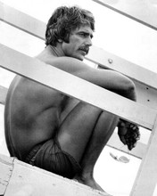 Sam Elliots sits in lifeguard swim shorts on tower 1976 Lifeguard 8x10 photo