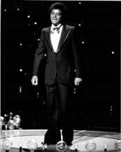 Johnny Mathis in tuxedo stands on TV stage performing 8x10 inch press photo