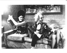 Beetlejuice Michael Keaton sits on sofa next to pair of legs 8x10 inch photo