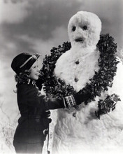 Shirley Temple puts Christmas wreath on snowman 8x10 inch photo