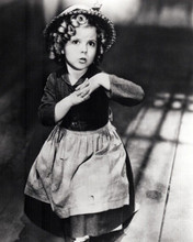 Shirley Temple strikes a cute pose in period apron and hat 8x10 inch photo