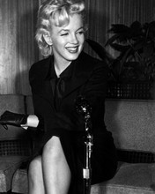 Marilyn Monroe smiles for cameras seated on sofa 8x10 inch photo