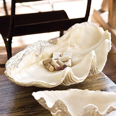 This large clam replica serves as a bowl or decorative object. Its resin construction beautifully mimics the details of a clam for a coastal feeling. Bring its shoreline style to a sideboard or coffee table in your living room.