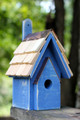 Brand new wooden bird house hand crafted with cypress wood construction featuring a copper trimmed and shingled roof with each shingle hand cut and stone washed.  Hand painted in a blueberry finish with light distressing.