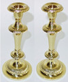 Pair of candlesticks featuring a traditional fluted design.  Crafted of brass with a rich polished brass finish.