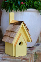 Brand new wooden bird house hand crafted with cypress wood construction featuring a copper trimmed and shingled roof with each shingle hand cut and stone washed.  Hand painted in yellow finish with light distressing.