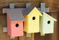 Brand new trio of bird houses mounted on a wooden trellis.  three cute-as-can-be wren houses are crafted of wood and beautifully hand painted in soft pastel hues.