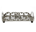 Paper guest towel holder showcasing a curvaceous foliate scroll motif surrounding the edges of the gallery.  Crafted of brass and finished in an antique silver patina.