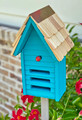 Brand new teal ladybug house hand crafted of solid wood with a shingled roof accented with a metal peak that will age and weather beautifully through the years.  The facade features three horizontal entryways/exits and a decorative ladybug applique.