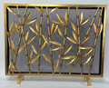 Brand new Asian inspired fireplace screen showcasing an elegant motif of stylized bamboo branches and leaves.  Crafted of iron with a rich antique gold patina and a protective wire mesh.