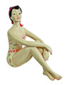 Nostalgic bathing beauty figurine clad in a strapless floral bathing suit, wears a red hair bow and sits cross-legged with her knees up.  Molded of resin and beautifully hand painted.