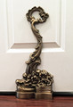 Scroll doorstop intricately cast of brass and finished with a rich antique brass patina.