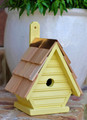 Brand new wooden bird house with clapboard siding.  Hand crafted of solid cypress wood featuring a hand-shingled roof and full copper trim; ventilation, drainage, rear cleaning door and mounting paddle for easy hanging.  Hand painted in a neon yellow hue.