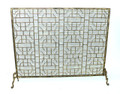 Brand new fireplace screen showcasing an elaborate geometric motif.  Crafted of iron with a light burnished gold finish and protective wire mesh