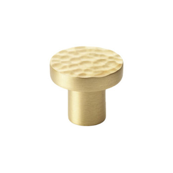 Hammered-style cupboard knob in satin brass. Circular face on a thick stem. 