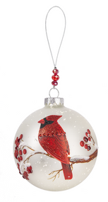 Round acrylic ornament with a painted cardinal sitting on a snowy branch. 